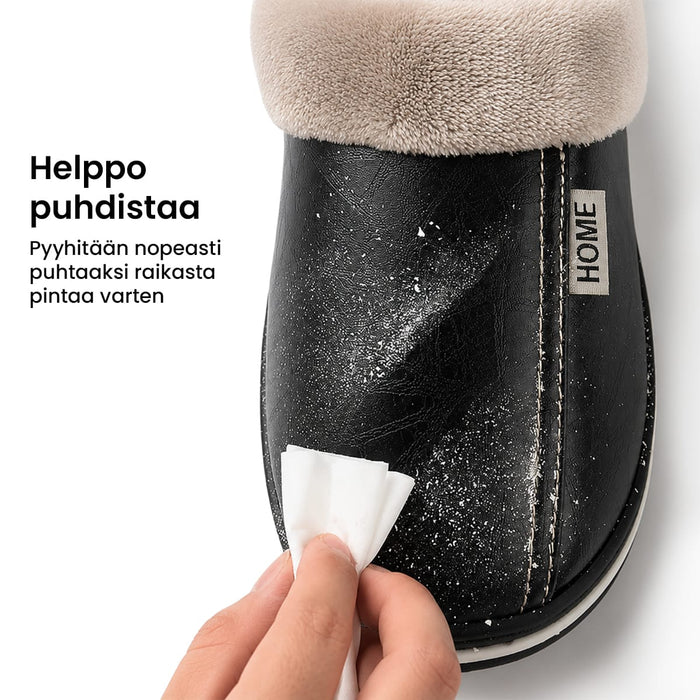 Käsi pyyhkii valkoisella liinalla nahkaisten sisätossujen pintaa, joissa lukee Helppo puhdistaa ja HOME.